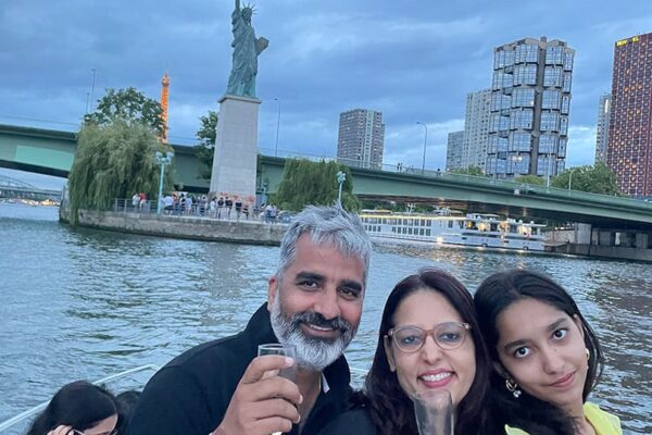 Croisière en famille. Couple trinquent avec coupe de Champagne devant la Statue de la Liberté